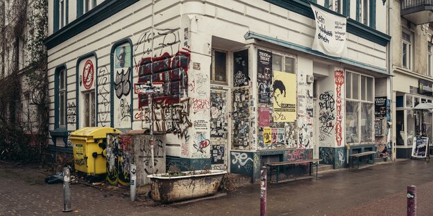 Ein Altbau, der mit Plakaten, Aufklebern und Graffiti versehen ist. Ein Altbau, der mit Plakaten, Aufklebern und Graffiti versehen ist.
