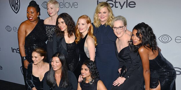 Vor einer Leinwand stehen Tarana Burke, Natalie Portman, Michelle Williams, Ai-jen Poo, America Ferrera, Jessica Chastain, Saru Jayaraman, Amy Poehler, Meryl Streep und Kerry Washington, alle tragen schwarze Kleider Vor einer Leinwand stehen Tarana Burke, Natalie Portman, Michelle Williams, Ai-jen Poo, America Ferrera, Jessica Chastain, Saru Jayaraman, Amy Poehler, Meryl Streep und Kerry Washington, alle tragen schwarze Kleider