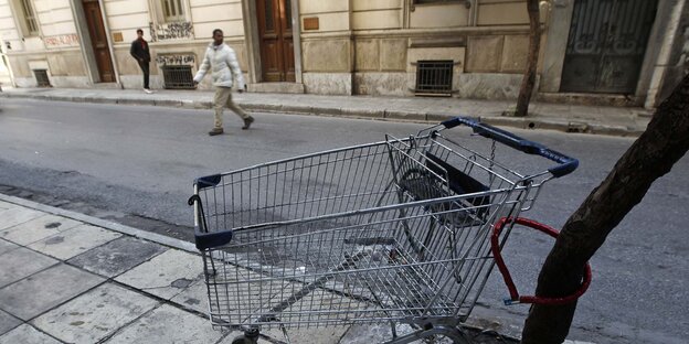 Auf einer Straße steht ein leerer Einkaufswagen Auf einer Straße steht ein leerer Einkaufswagen