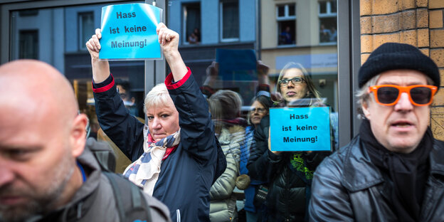 Menschen halten Schilder mit der Aufschrift "Hass ist keine Meinung"