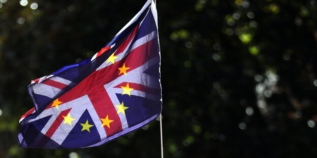 Eine britische und eine EU-Flagge wehen übereinandergelegt im Wind Eine britische und eine EU-Flagge wehen übereinandergelegt im Wind