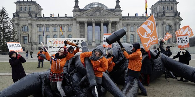 Menschen erlegen symbolisch vor dem Bundestag ein Plastikmonster. Menschen erlegen symbolisch vor dem Bundestag ein Plastikmonster.