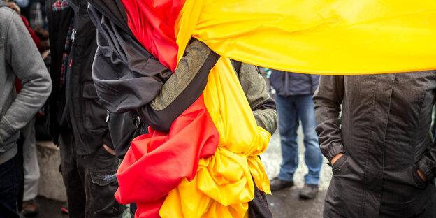 Jemand krallt sich in eine Deutschlandfhane Jemand krallt sich in eine Deutschlandfhane