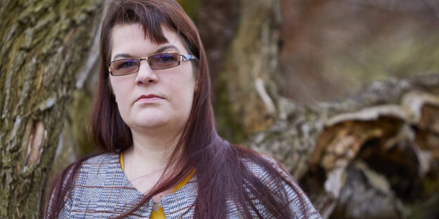 Eine Frau mit langen roten Haaren und Sonnenbrille blickt in die Kamera. Eine Frau mit langen roten Haaren und Sonnenbrille blickt in die Kamera.