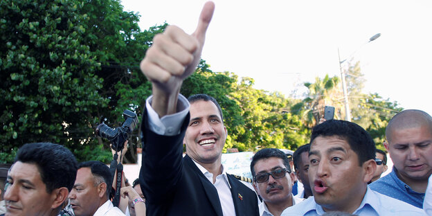 Juan Guaido reckt in einer Menschenmenge lächelnd den Daumen in die Luft Juan Guaido reckt in einer Menschenmenge lächelnd den Daumen in die Luft