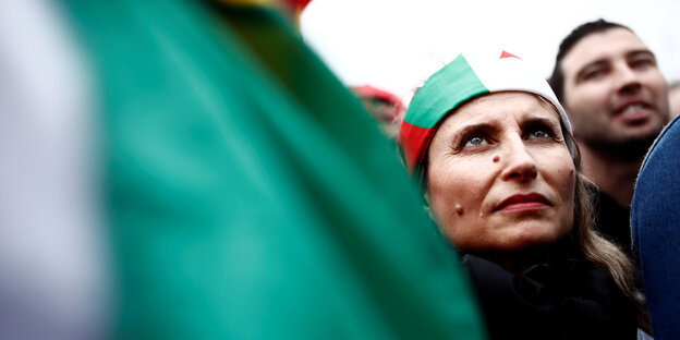 Porträt einer Demonstrantin neben einer Flagge Porträt einer Demonstrantin neben einer Flagge