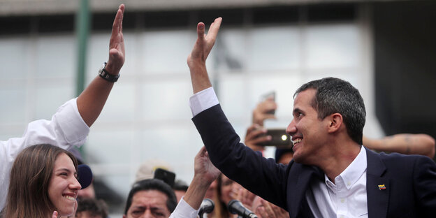 Ein Mann klatscht in die Hand einer anderen Person. Es ist Juan Guaidó Ein Mann klatscht in die Hand einer anderen Person. Es ist Juan Guaidó