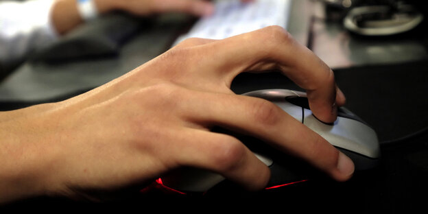 Eine Hand liegt auf einer Computermaus Eine Hand liegt auf einer Computermaus