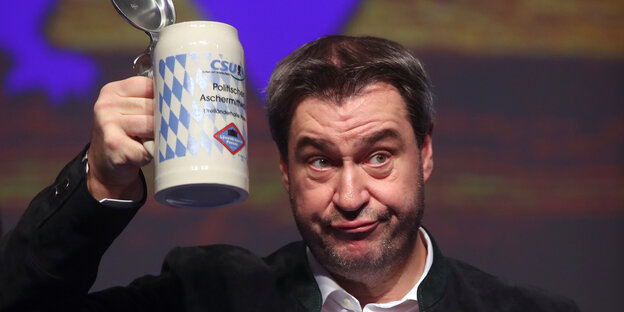 Markus Söder hält einen Bierkrug in die Luft Markus Söder hält einen Bierkrug in die Luft