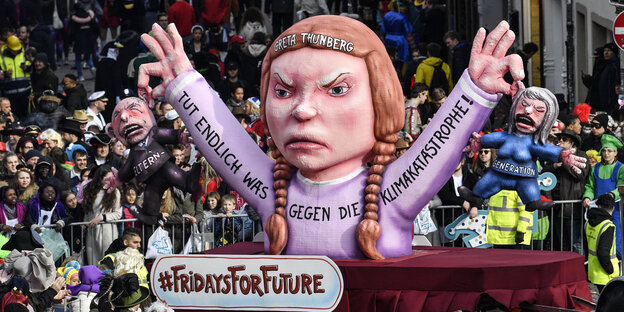 Karnevalswagen zeigt Aktivistin Greta Thunberg, die die Elterngeneration am Kragen packt Karnevalswagen zeigt Aktivistin Greta Thunberg, die die Elterngeneration am Kragen packt