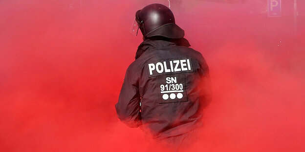 Vier Polizisten vor einem Backsteingebäude mit Graffiti Vier Polizisten vor einem Backsteingebäude mit Graffiti