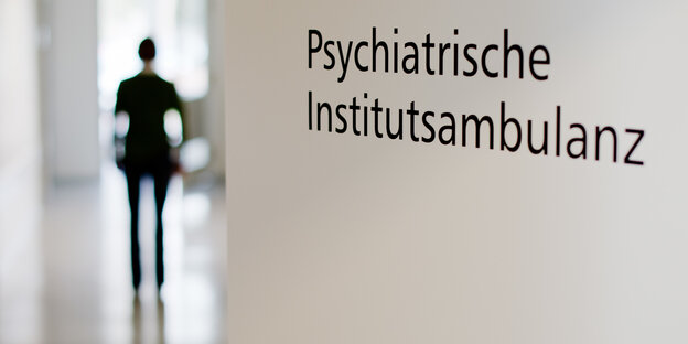 Eine Person hinter einer geöffneten Tür Eine Person hinter einer geöffneten Tür