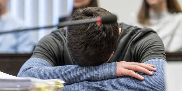 Der Angeklagte Ali B. hat zum Prozessauftakt im Gerichtssaal den Kopf auf die Arme gelegt. Der Angeklagte Ali B. hat zum Prozessauftakt im Gerichtssaal den Kopf auf die Arme gelegt.