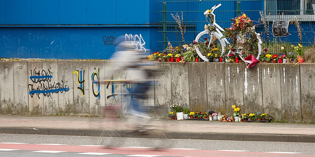 Weißes Fahrad steht mit Blumen geschmückt auf einer Mauer Weißes Fahrad steht mit Blumen geschmückt auf einer Mauer