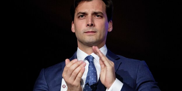 Ein Mann im Anzug klatscht in die Hände Ein Mann im Anzug klatscht in die Hände