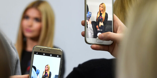 Zwei menschen fotografieren die Influencerin Pamela Reif, die gerade ein Interview gibt Zwei menschen fotografieren die Influencerin Pamela Reif, die gerade ein Interview gibt