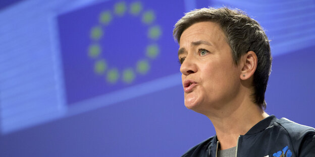 Margrethe Vestager, dahinter eine EU-Flagge