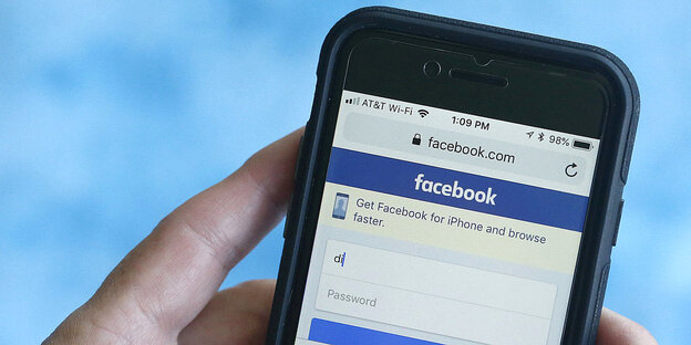 Eine Person loggt auf ihrem Smartphone auf Facebook ein Eine Person loggt auf ihrem Smartphone auf Facebook ein