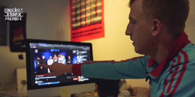 Der Journalist Hubertus Koch zeigt auf einen Laptop, auf dem ein Ausschnitt eines Rapbattlevideos zu sehen ist Der Journalist Hubertus Koch zeigt auf einen Laptop, auf dem ein Ausschnitt eines Rapbattlevideos zu sehen ist