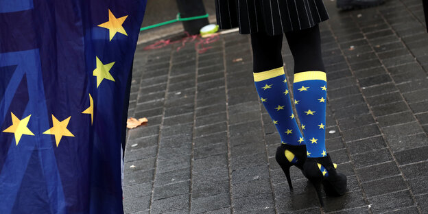 Eine Frau trägt blaua Socken mit gelben Sternen, der EU-Flagge ähnlich Eine Frau trägt blaua Socken mit gelben Sternen, der EU-Flagge ähnlich