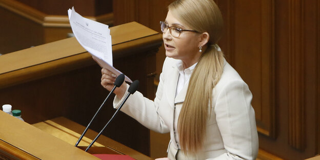 Frau mit langen blonden Haaren und Blättern in der Hand Frau mit langen blonden Haaren und Blättern in der Hand