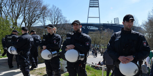 Polizisten stehen vor einem Stadion Polizisten stehen vor einem Stadion