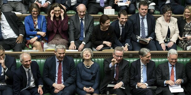 Abgeordnete sitzen im britischen Parlament auf den Bänken. Viele lachen. Abgeordnete sitzen im britischen Parlament auf den Bänken. Viele lachen.