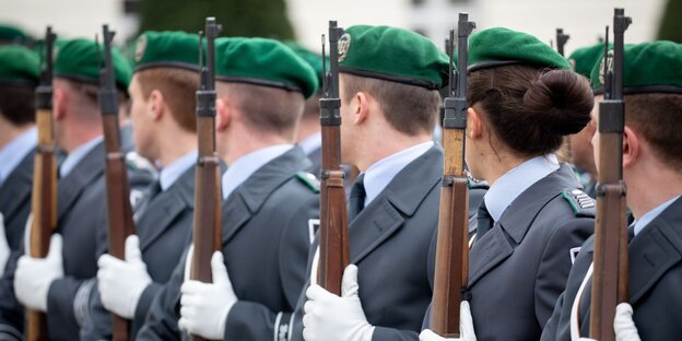 Soldaten und Soldatinnen vom Wachbataillon der Bundeswehr stehen nebeneinander mit Gewehren in der Hand. Soldaten und Soldatinnen vom Wachbataillon der Bundeswehr stehen nebeneinander mit Gewehren in der Hand.