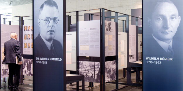 Ein Mann steht vor Ausstellungstafeln, auf denen die NS-Politiker Werner Mansfeld und Wilhelm Börger zu sehen sind Ein Mann steht vor Ausstellungstafeln, auf denen die NS-Politiker Werner Mansfeld und Wilhelm Börger zu sehen sind