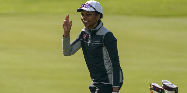 Condoleezza Rice trägt Sportkleidung und steht auf einem Goldplatz Condoleezza Rice trägt Sportkleidung und steht auf einem Goldplatz