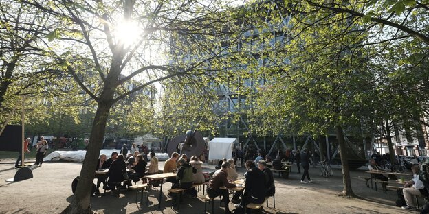 Menschen sitzen vor dem taz Neubau Menschen sitzen vor dem taz Neubau