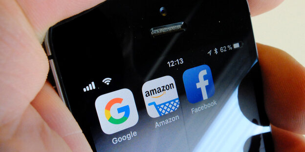Eine Hand hält ein Telefon, auf dem sich Apps wie die von Facebook befinden Eine Hand hält ein Telefon, auf dem sich Apps wie die von Facebook befinden
