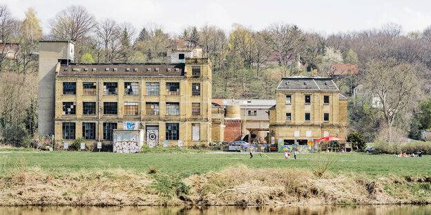 Ein Fabrikgebäude steht am Wasser Ein Fabrikgebäude steht am Wasser