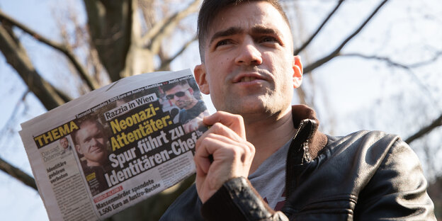 Ein Mann hält eine Boulevardzeitung in der Hand Ein Mann hält eine Boulevardzeitung in der Hand