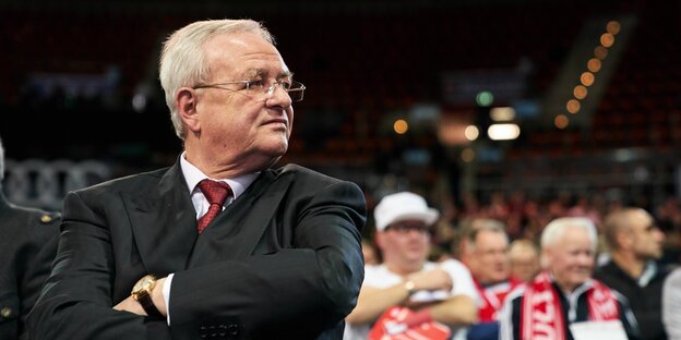 Martin Winterkorn verschränkt die Arme und schaut zur Seite - in einem Stadion