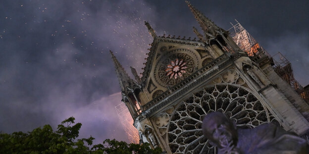 Funken fliegen über einer Kathedrale, aus der Feuer austritt Funken fliegen über einer Kathedrale, aus der Feuer austritt