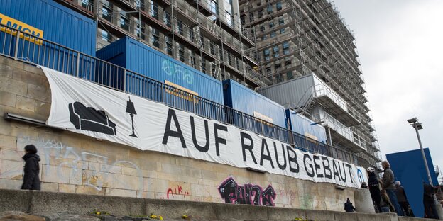 An einem Neubau hängt ein Transparent mit der Aufschrift "Auf Raub gebaut". An einem Neubau hängt ein Transparent mit der Aufschrift "Auf Raub gebaut".