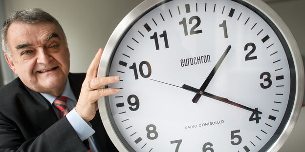 Porträt Herbert Reul mit einer großen Uhr Porträt Herbert Reul mit einer großen Uhr
