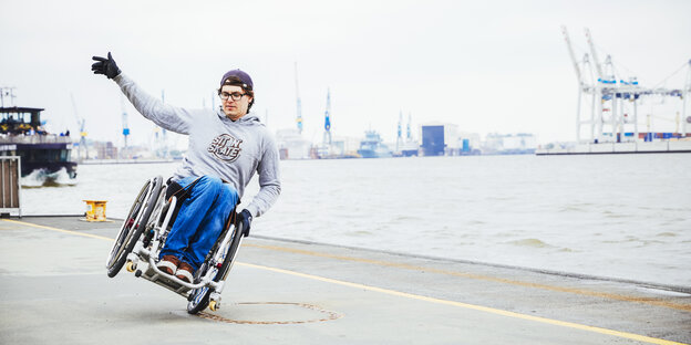 David Lebuser skatet auf einem Reifen seines Rollstuhls David Lebuser skatet auf einem Reifen seines Rollstuhls