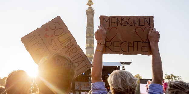 „Menschenrechte" und „Solidarität" steht bei der Abschlusskundgebung der Demonstration gegen Rassismus und Rechtsruck mit dem Motto «Unteilbar» vor der Berliner Siegessäule auf zwei Schildern. „Menschenrechte" und „Solidarität" steht bei der Abschlusskundgebung der Demonstration gegen Rassismus und Rechtsruck mit dem Motto «Unteilbar» vor der Berliner Siegessäule auf zwei Schildern.