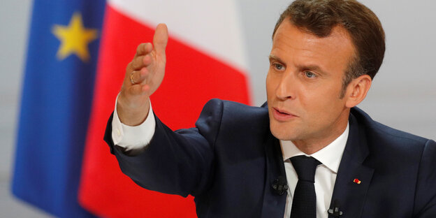 Emmanuell Macron mit erhobener Hand Emmanuell Macron mit erhobener Hand
