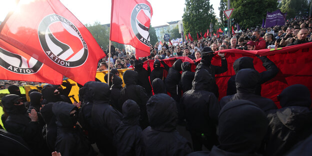 schwarz gekleidete und vermummte Menschen demonstrieren mit Antifa-Fahnen in Kreuzberg schwarz gekleidete und vermummte Menschen demonstrieren mit Antifa-Fahnen in Kreuzberg