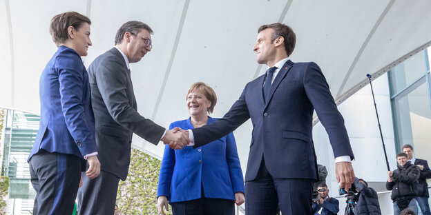 Frankreichs Staatschef Emmanuel Macron begrüßt mit einem überschwänglichen Handschlag Aleksandar Vucic (2.v.l.), Staatspräsident von Serbien. Dahinter steht Angela Merkel. Frankreichs Staatschef Emmanuel Macron begrüßt mit einem überschwänglichen Handschlag Aleksandar Vucic (2.v.l.), Staatspräsident von Serbien. Dahinter steht Angela Merkel.