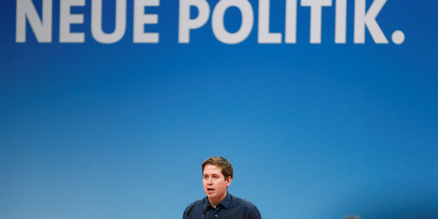 Juso-Chef Kevin Kühnert am Rednerpult. Hinter ihm prangt der Slogan "Neue Politik" Juso-Chef Kevin Kühnert am Rednerpult. Hinter ihm prangt der Slogan "Neue Politik"