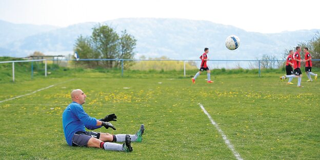 Torwart Patrik Herak sitzt auf dem Boden eines Fußballplatzes. Torwart Patrik Herak sitzt auf dem Boden eines Fußballplatzes.