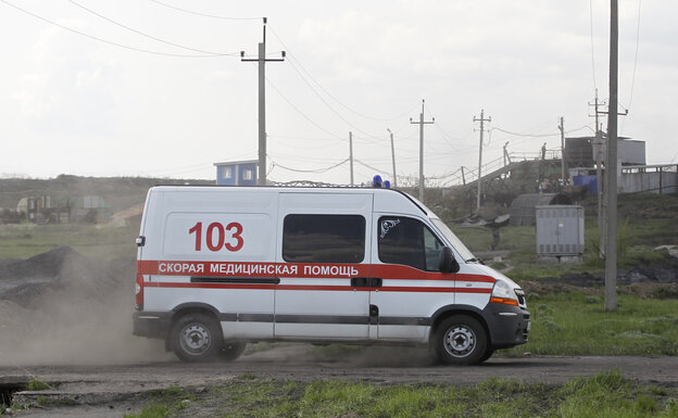 Ein Rettungswagen rast eine staubige Straße in der Ukraine entlang. Ein Rettungswagen rast eine staubige Straße in der Ukraine entlang.