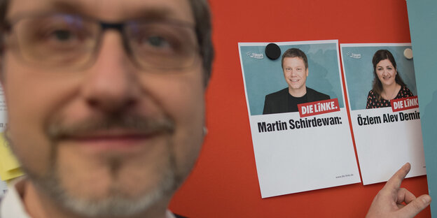 örg Schindler, Bundesgeschäftsführer der Partei Die Linke, zeigt bei einer Begehung des EU-Wahlquartiers in der Parteizentrale auf Fotos der Spitzenkandidaten zur Europawahl, Martin Schirdewan und Özlem Alev Demirel