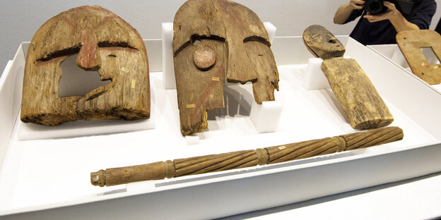 Holzmasken und Stäbe austgestellt auf einer Platte im Museum Holzmasken und Stäbe austgestellt auf einer Platte im Museum