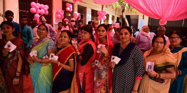 Frauen in Sari in einer Wahlschlange Frauen in Sari in einer Wahlschlange