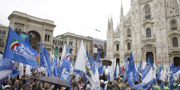 Vor dem Dom in Mailand ist eine große Menschenmenge mit vielen blau-weißen Fahnan Vor dem Dom in Mailand ist eine große Menschenmenge mit vielen blau-weißen Fahnan